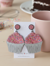 Glitter cupcake drop earrings on card, pink frosting with rainbow sprinkles and silver glitter base