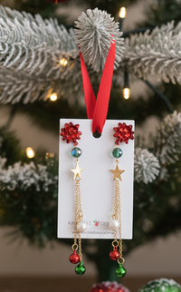 Christmas drop earrings on card showing red bow, gold star, pearl and jingle bell charms on gold chains