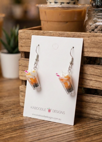 Pair of resin milkshake drop earrings on a Kaboodle Designs card, showing whipped cream and straw detail