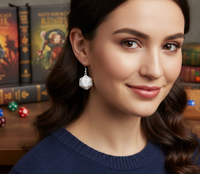 Close-up of white D20 die earring worn on model's ear, numbered faces visible