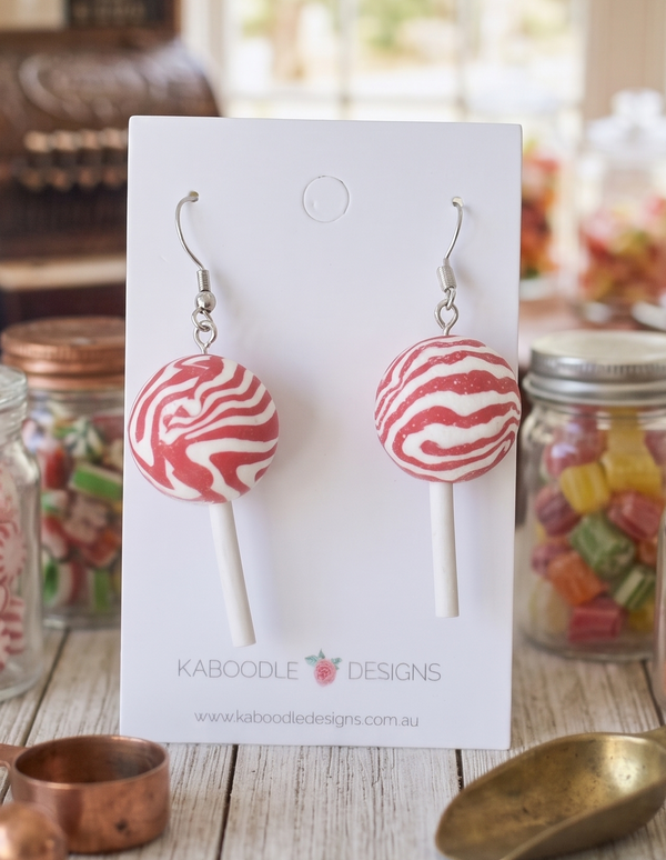 Pink and white peppermint swirl lollipop resin drop earrings on a Kaboodle Designs card