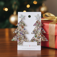 Glitter acrylic Christmas tree drop earrings with star stud top on white display card, gift box in background
