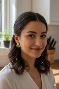 Close-up of avocado stud earring worn on a model's ear