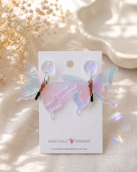 Pair of iridescent Perspex butterfly drop earrings on a Kaboodle Designs card