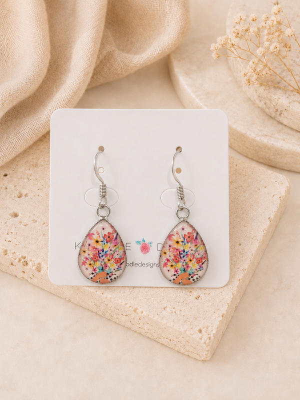 Teardrop earrings on card featuring a printed bouquet of pink, red and yellow flowers in a spotted vase