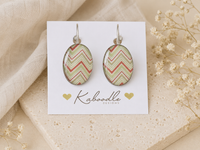 Oval chevron drop earrings in sage green and coral on a Kaboodle Designs display card
