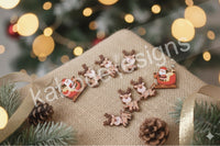 Loose acrylic Santa sleigh and reindeer charms arranged on a woven fabric with pinecones