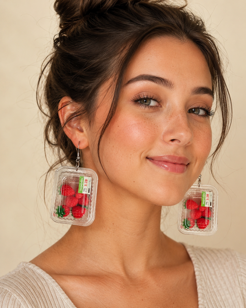 Close-up of a model wearing strawberry punnet dangle earrings, showing the clear punnet detail and price sticker