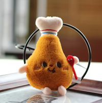 Plush drumstick keychain with chef's hat and smiling face, front view against a circular backdrop