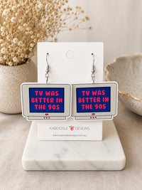Pair of retro TV-shaped dangle earrings with pink text reading TV Was Better in the 90s on a blue screen