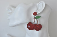 Side view of glitter cherry earring worn on a display ear model