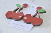 Back view of cherry earrings showing zinc alloy hardware and heart cut-out detail