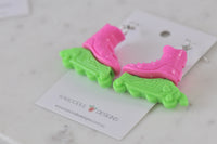 Rollerblade earrings resting on a marble surface beside the Kaboodle Designs card