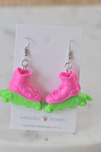 Pair of hot pink and green rollerblade drop earrings on a Kaboodle Designs card