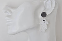 Close-up of ghost earring worn on ear showing glittery stud and painted ghost face detail