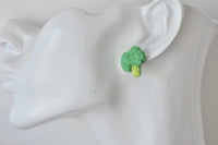 Close-up of a single broccoli stud earring worn on a model's ear