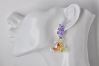Close-up of gummy bear bag drop earring worn on ear, showing resin candy detail