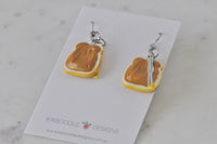 Back view of peanut butter toast earrings showing resin texture and silver knife detail