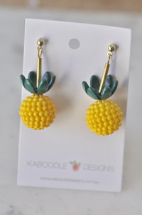 Yellow pineapple dangle earrings with green top and gold stem, on Kaboodle Designs card
