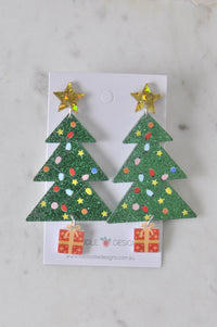Front view of Christmas tree earrings on white card showing star, tree and gift design in detail