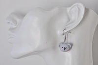 Close-up of koala earring worn on ear, showing alloy hook and glossy resin finish