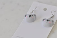 Koala drop earrings laid flat on Kaboodle Designs card, front view of both faces