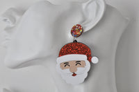 Santa Claus earring worn on ear, close-up showing tongue-out smiling face