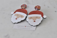 Angled view of Santa earrings showing glossy red hat and white beard detail