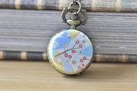 Bronze-tone pocket watch necklace featuring three bluebirds on a blossoming branch design