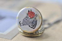 Close-up of zebra and rose design on round pocket watch pendant