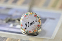 Close-up of the 'Dream' floral wreath design on the pocket watch necklace pendant