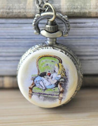 Alice in Wonderland pocket watch necklace showing Alice seated on a green armchair holding an apple