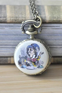 Mad Hatter pocket watch necklace pendant resting on a stack of books