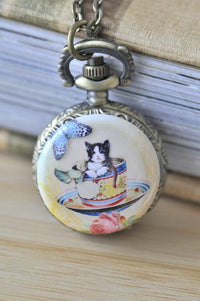 Cat in a teacup pocket watch necklace with butterfly and rose artwork on antique bronze case