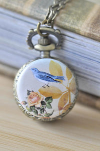 Antique brass pocket watch necklace with bluebird and rose artwork on the lid