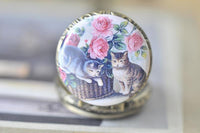Close-up of cat and rose pendant design on antique bronze pocket watch necklace
