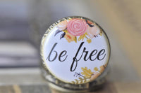 Close up of the be free floral pocket watch pendant with pink and gold blooms