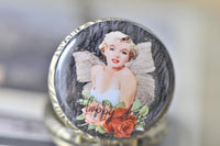 Close-up of Marilyn Monroe portrait pocket watch pendant with wings and rose detail