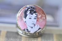Close-up of Audrey Hepburn portrait glass dome on ornate bronze pocket watch pendant