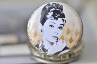 Close-up of the Audrey Hepburn portrait on the round pocket watch pendant lid