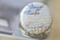 Close-up of bluebird and vintage French script artwork on pocket watch pendant lid
