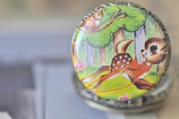 Close-up of the vintage woodlands fawn and squirrel design on the pocket watch pendant