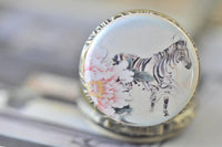 Close up of the zebra and rose watercolour artwork on the pocket watch pendant lid
