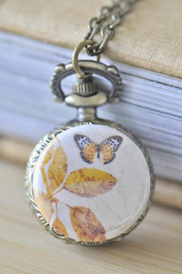 Antique brass pocket watch necklace with vintage butterfly and golden leaf artwork on chain