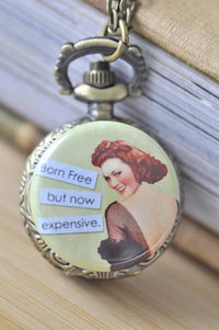 Bronze pocket watch necklace with a retro pin up girl and 'Born Free but now expensive' caption
