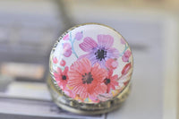 Close-up of watercolour floral pocket watch pendant lid with pink poppies and purple blooms