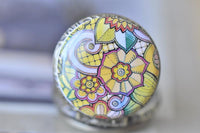 Detailed view of the colourful floral swirl artwork under glass on the pocket watch pendant