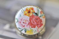 Close-up of the watercolour floral artwork on the pocket watch pendant