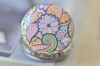 Top-down close-up of the colourful floral paisley pattern on the pocket watch pendant lid