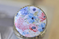 Close-up of watercolour floral pocket watch pendant design with anemones and hydrangeas